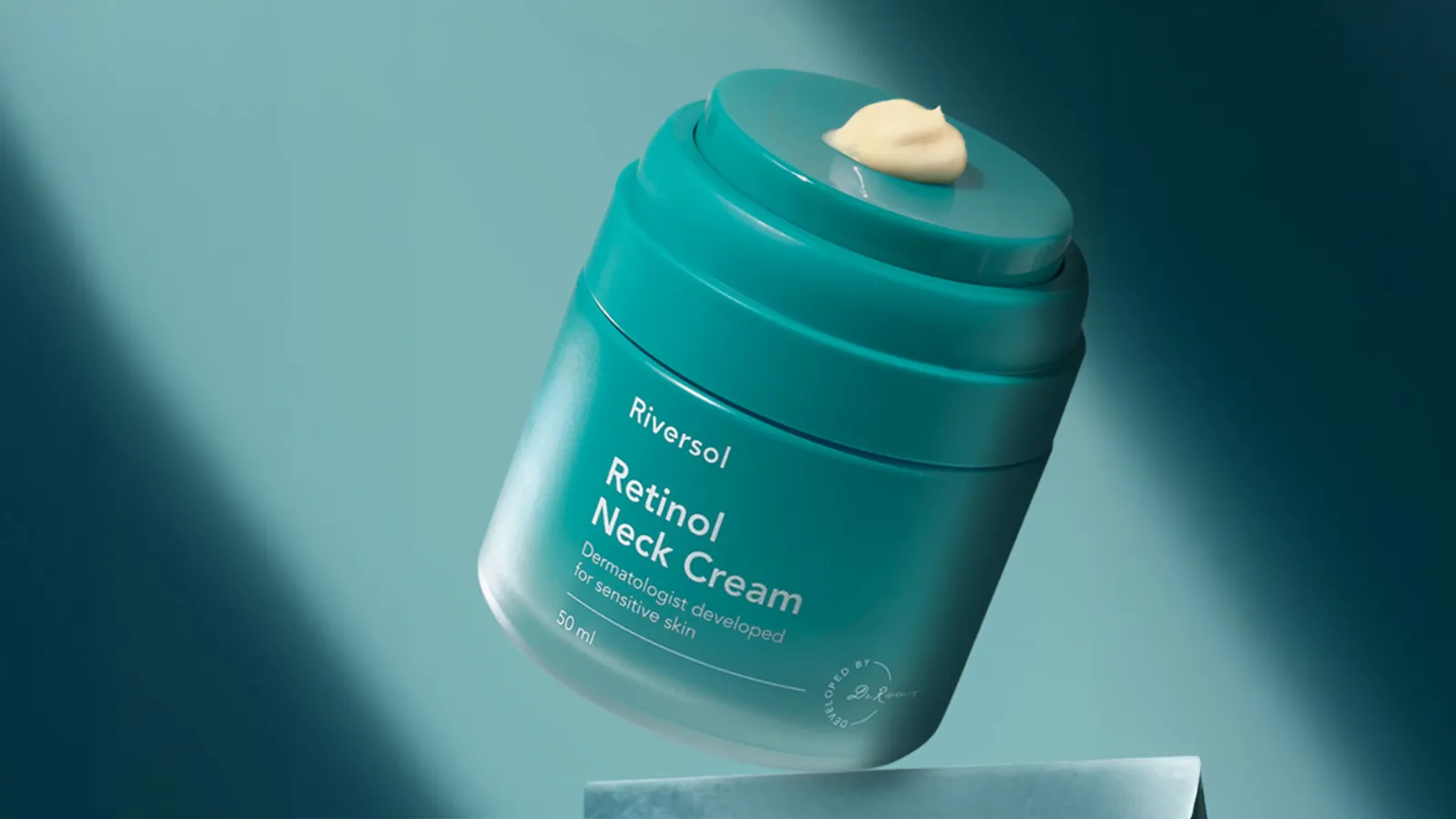 Riversol Retinol Neck Cream jar on teal background